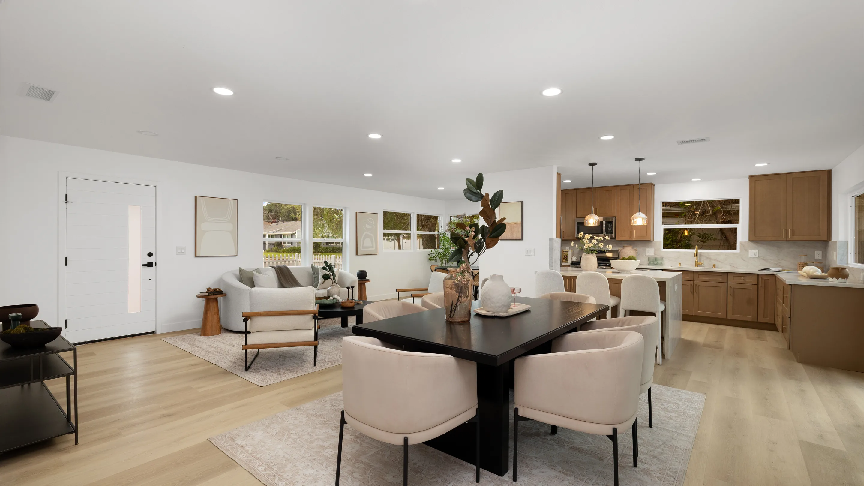 A dining table set in an open-plan room, kitchen beyond